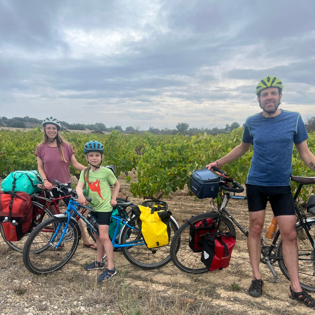 Family cycling through the vineyards
